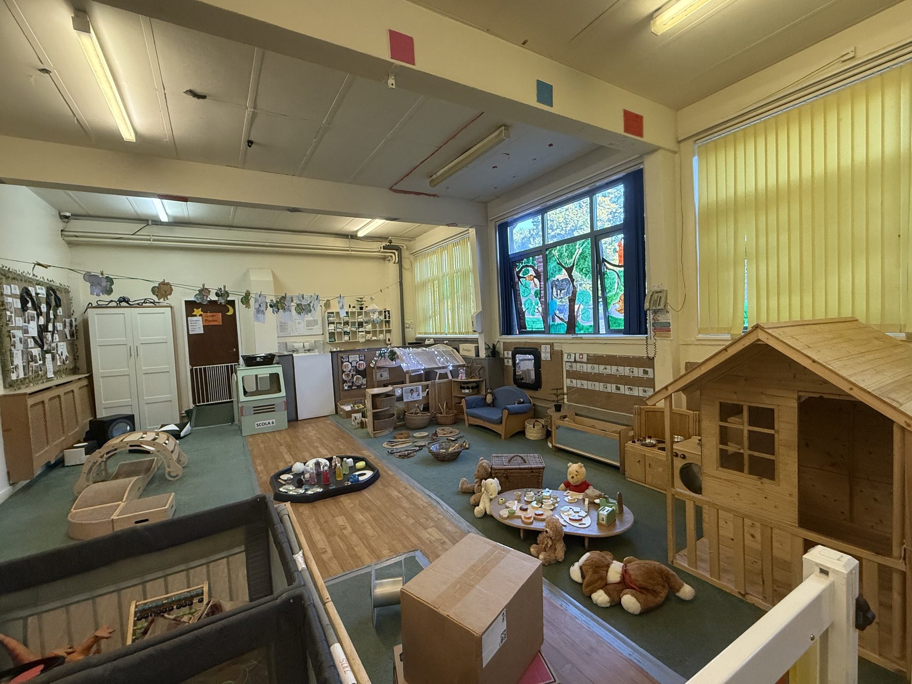 Inside the baby room: soft toys, sensory play trays and a wooden play house