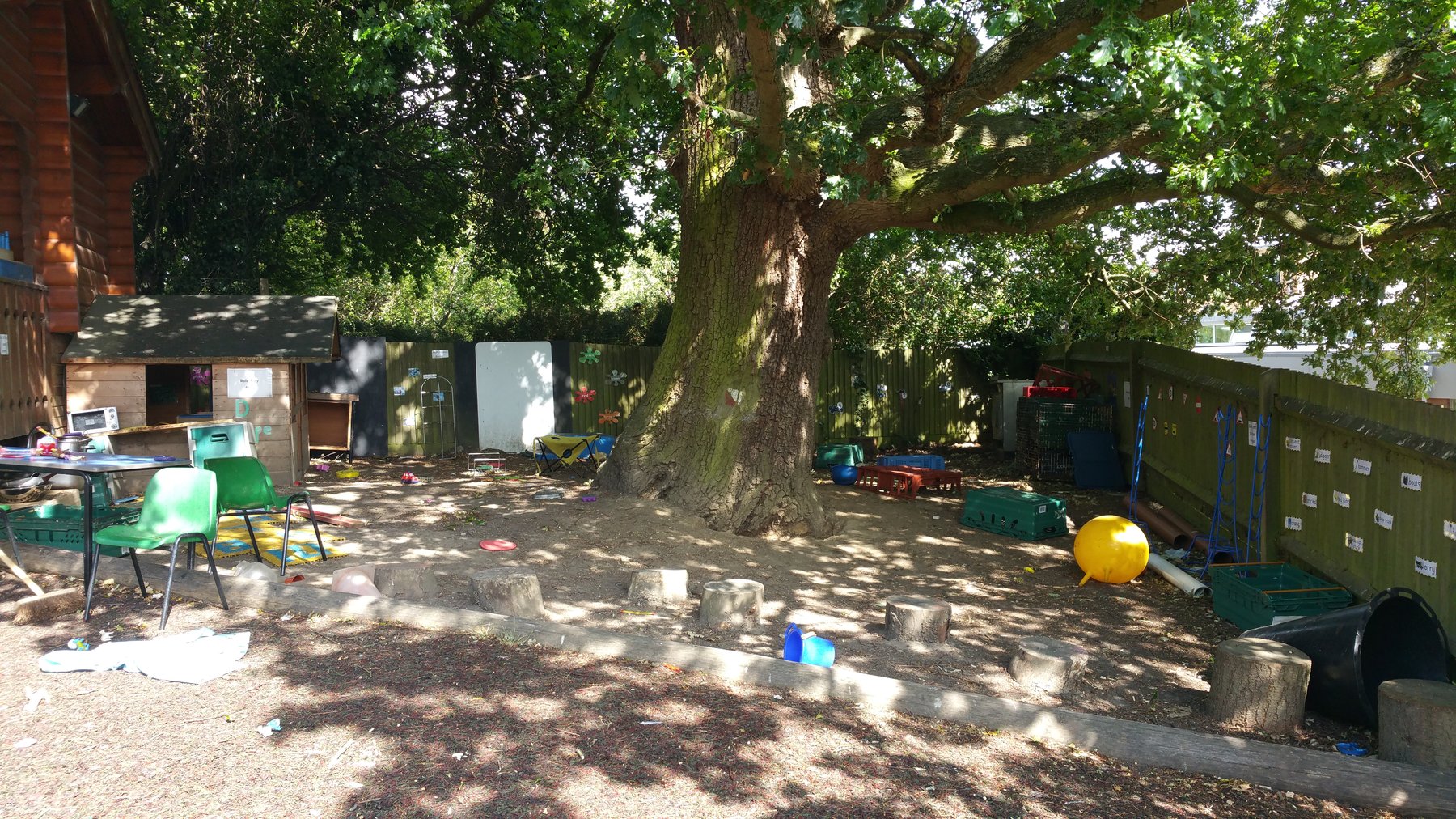 Outdoor garden play area with tree and playhouse